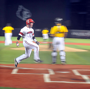Kirk Gibson jumps on home plate for UofL's first run, thanks to a single by Nick Solac.